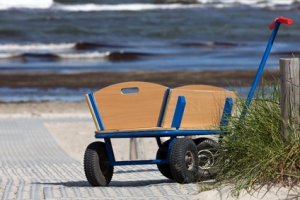 Bollerwagen steht allein am Wegesrand zum Strand